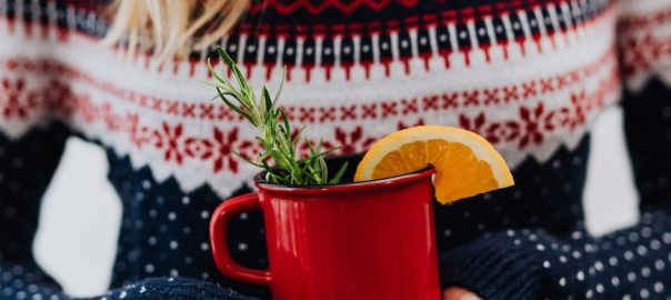 a person holding red ceramic mug