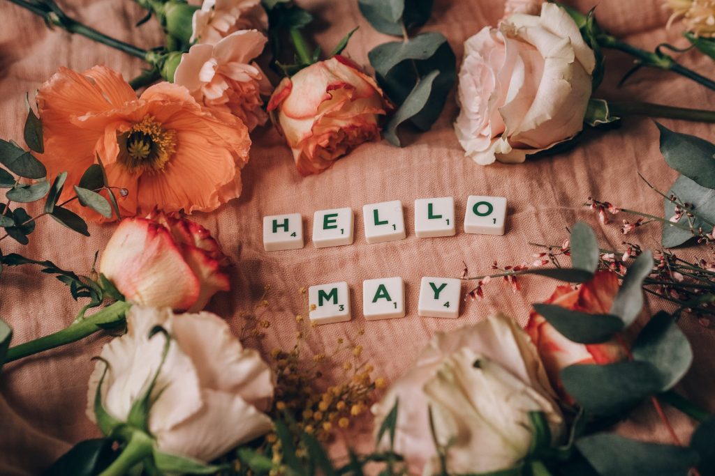 close up shot of scrabble tiles beside flowers