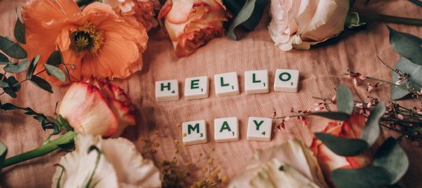 close up shot of scrabble tiles beside flowers